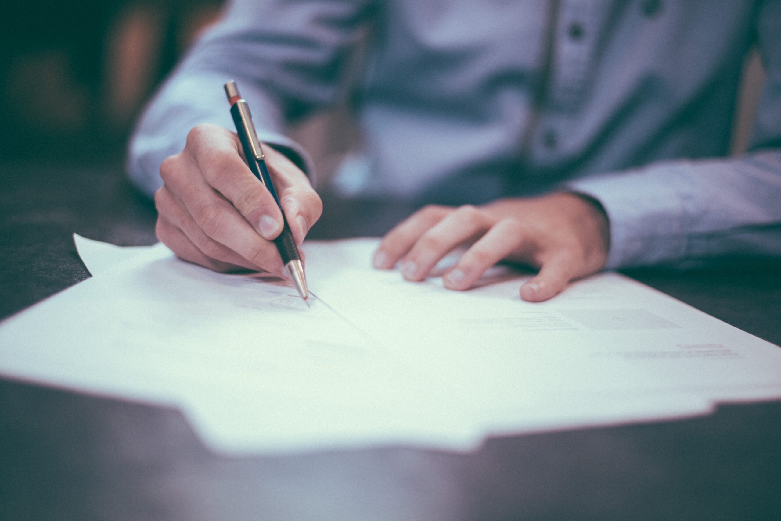 Person signing mortgage paperwork.